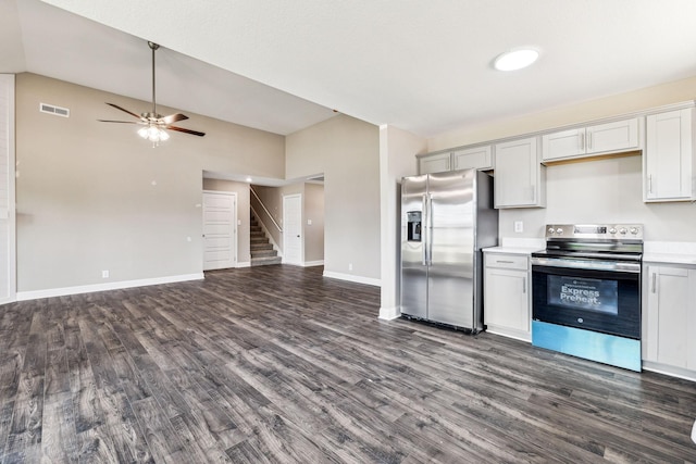 kitchen with dark wood-style floors, open floor plan, appliances with stainless steel finishes, light countertops, and lofted ceiling