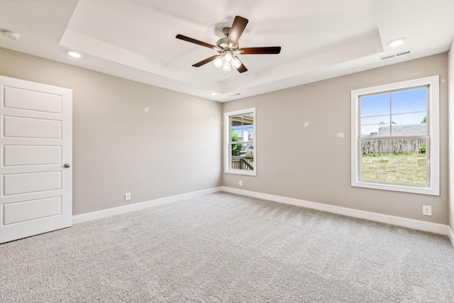 empty room with visible vents, baseboards, recessed lighting, a raised ceiling, and carpet flooring