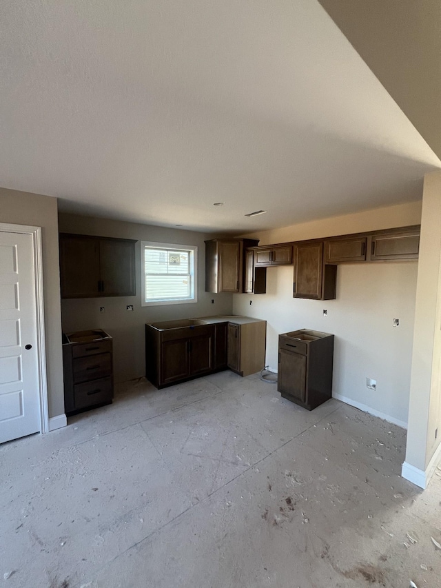 kitchen featuring dark brown cabinetry and baseboards