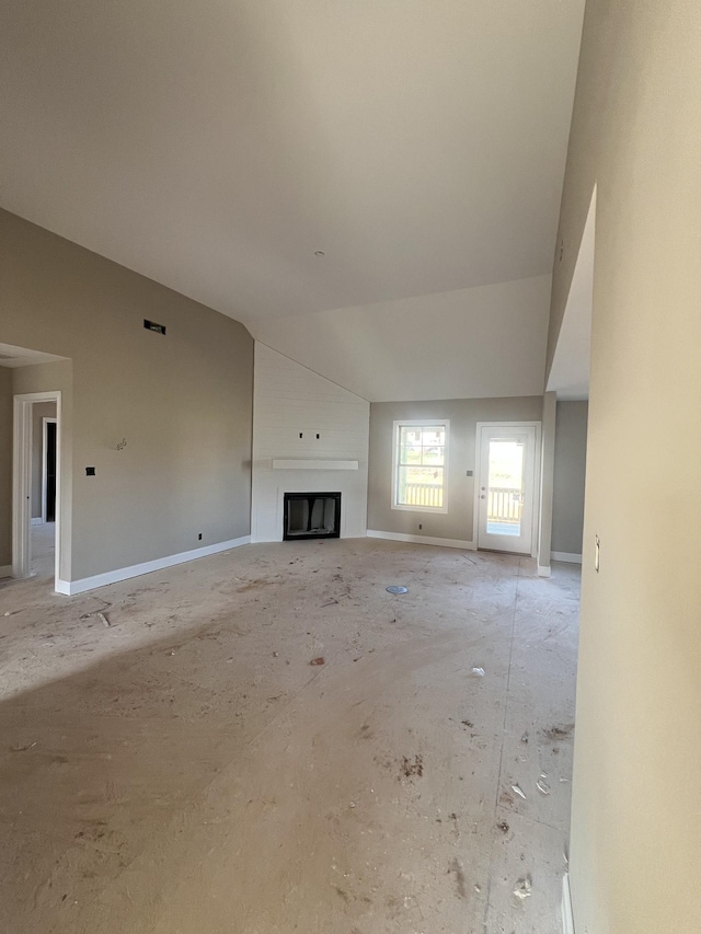 unfurnished living room with baseboards, a large fireplace, and lofted ceiling