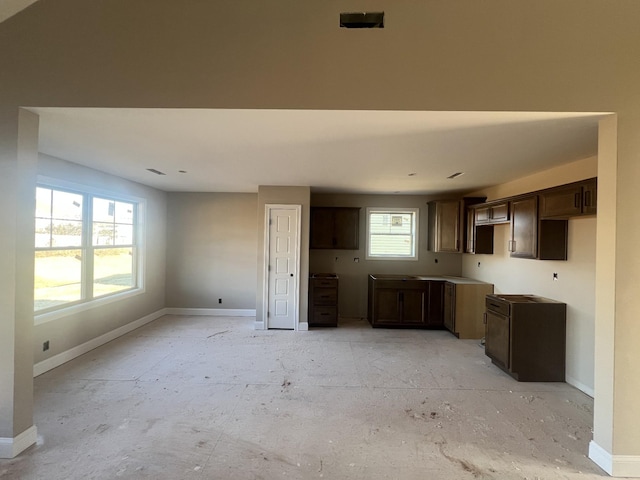 kitchen featuring baseboards and dark brown cabinets