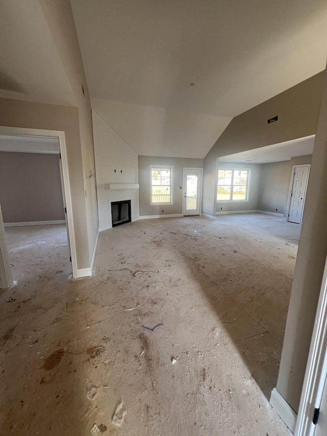 unfurnished living room with visible vents, baseboards, a fireplace, and vaulted ceiling