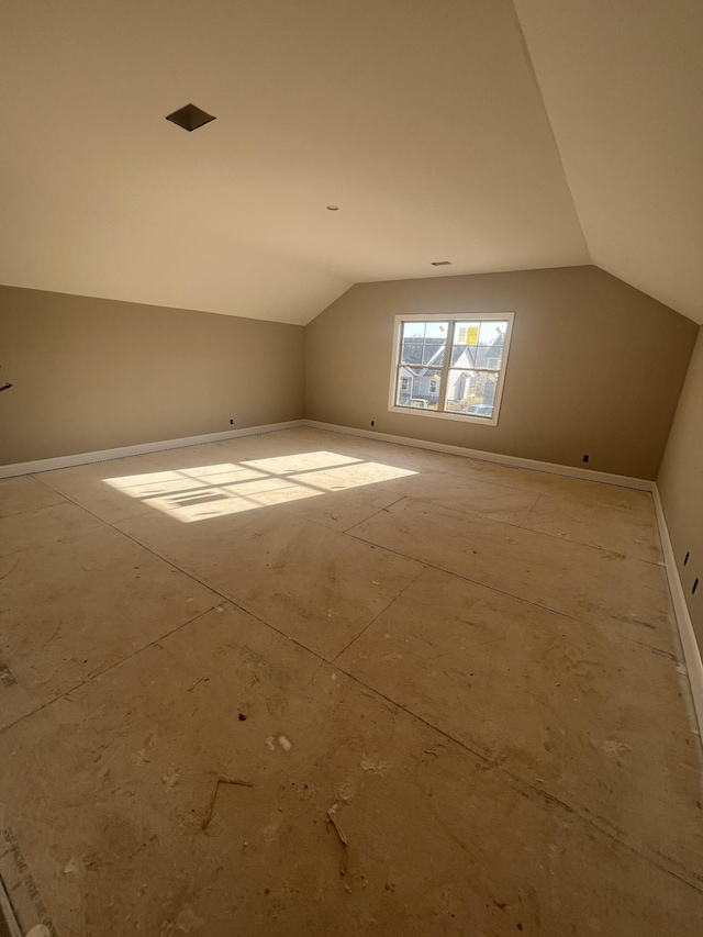 bonus room with baseboards and vaulted ceiling