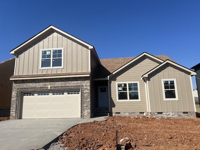 view of front of property featuring an attached garage, a shingled roof, concrete driveway, crawl space, and board and batten siding