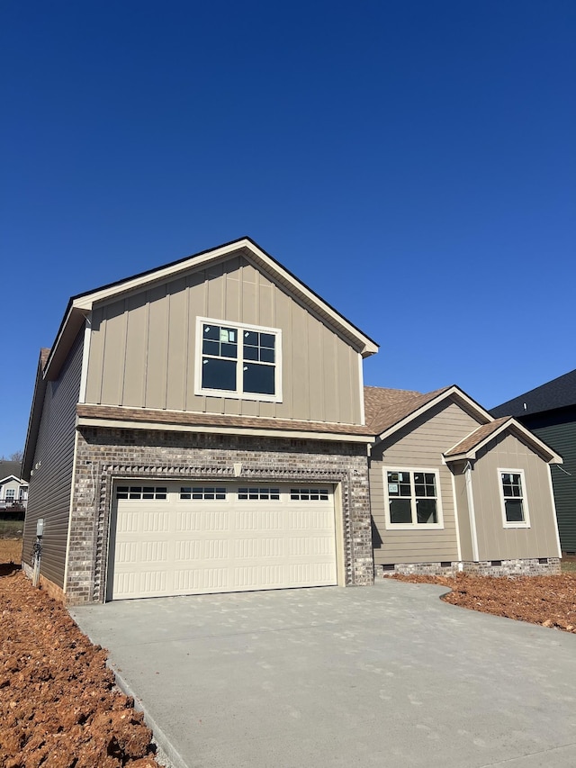 view of front of house with brick siding, concrete driveway, a garage, crawl space, and board and batten siding