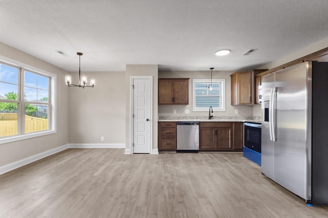 130 Anderson Pl, Clarksville, TN 37042 - kitchen with stainless steel appliances, an inviting chandelier, light countertops, a sink, and light wood-style floors