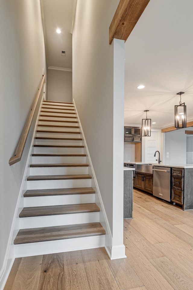 stairway featuring hardwood / wood-style flooring and sink