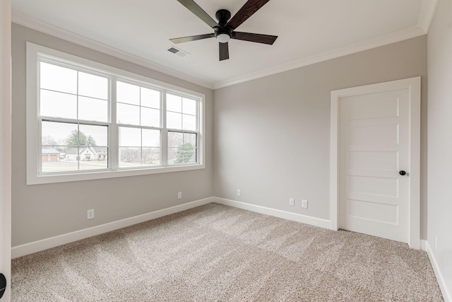 carpeted spare room featuring ceiling fan and crown molding