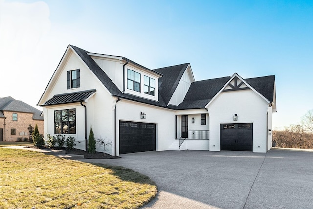 modern inspired farmhouse with a garage and a front lawn