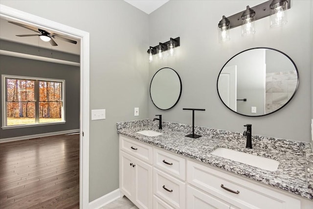 bathroom with ceiling fan, vanity, and wood-type flooring