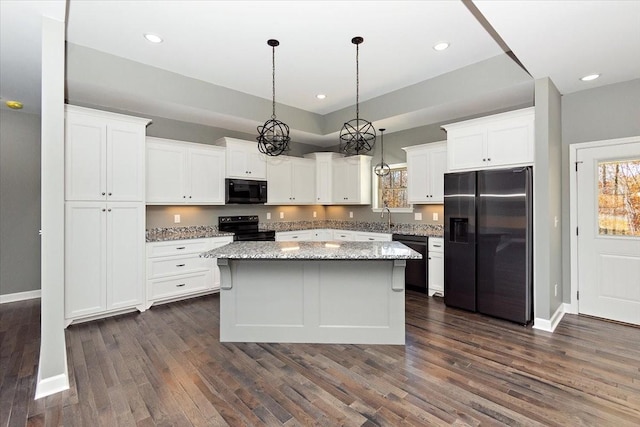 kitchen featuring black appliances, decorative light fixtures, white cabinets, and dark wood-type flooring