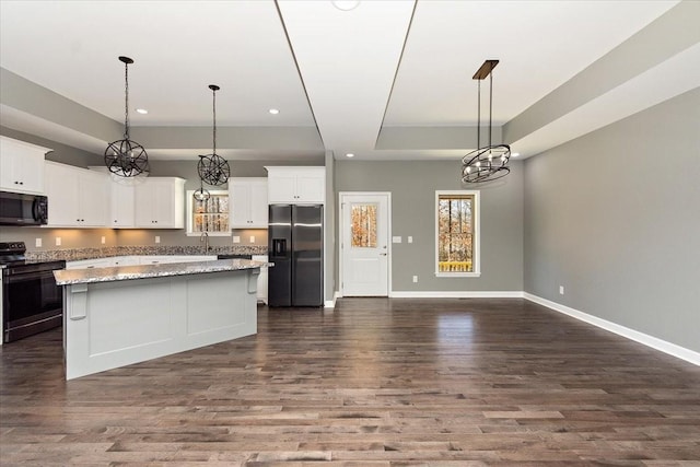 kitchen with a center island, dark hardwood / wood-style floors, pendant lighting, white cabinets, and appliances with stainless steel finishes