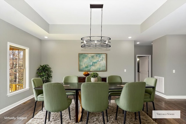 dining space with dark hardwood / wood-style flooring and an inviting chandelier