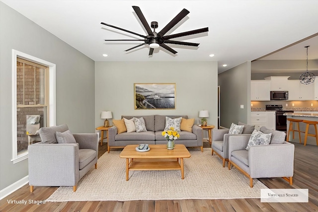 living room with ceiling fan and light wood-type flooring