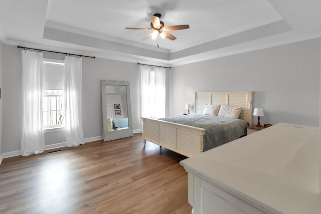 bedroom featuring multiple windows, ceiling fan, light hardwood / wood-style flooring, and ornamental molding