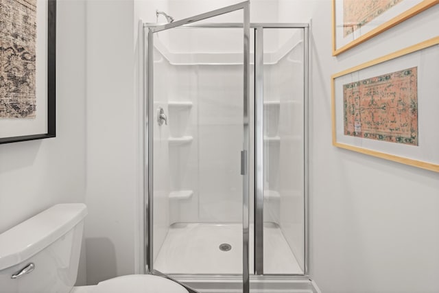 bathroom with toilet and a shower with shower door