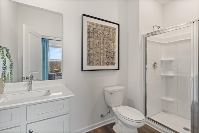 bathroom with vanity, toilet, a shower with shower door, and wood-type flooring