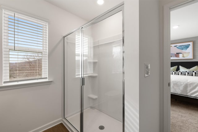 bathroom featuring a shower with shower door and a wealth of natural light