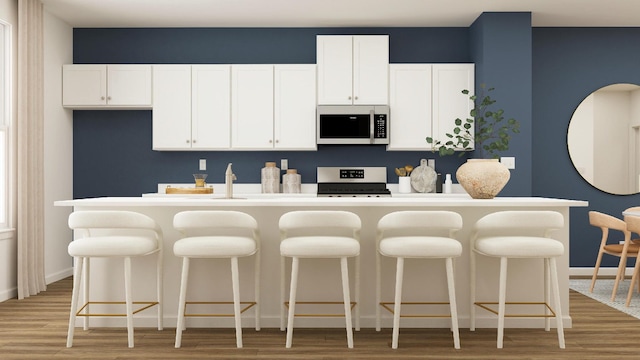 kitchen featuring white cabinets, a kitchen island, light hardwood / wood-style flooring, and gas range