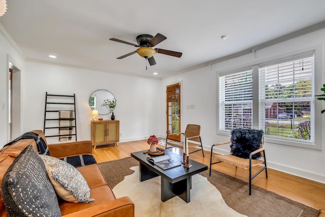 living room with crown molding, ceiling fan, and light hardwood / wood-style floors