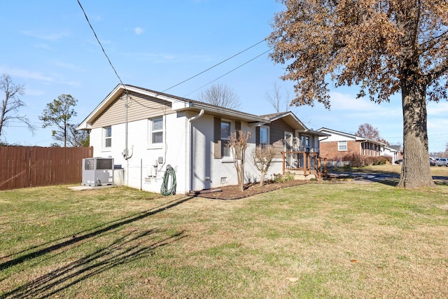 view of property exterior featuring central AC unit and a lawn