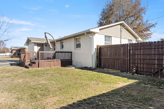 rear view of house featuring a deck and a lawn