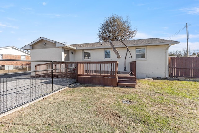 rear view of property featuring a deck and a lawn