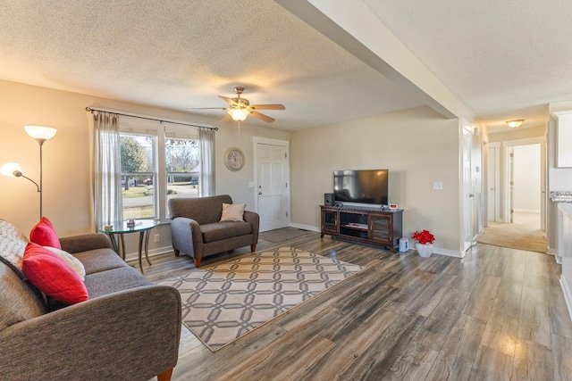 living room featuring hardwood / wood-style floors, ceiling fan, and a textured ceiling