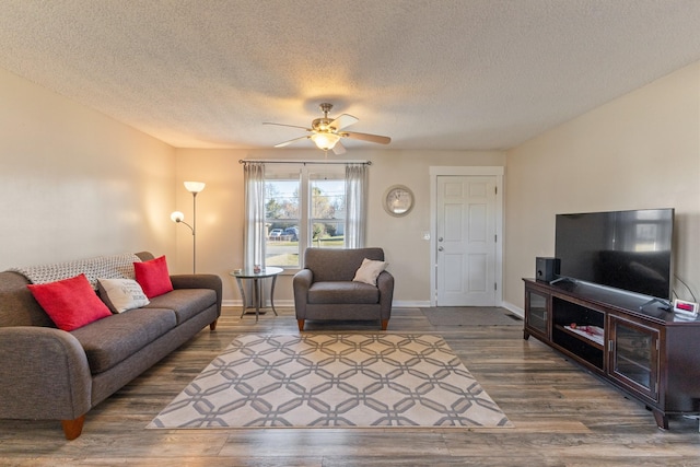 living room with ceiling fan, dark hardwood / wood-style flooring, and a textured ceiling