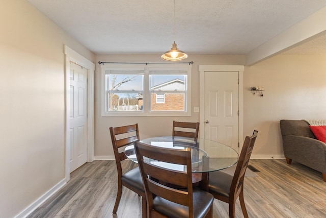 dining area featuring hardwood / wood-style floors and a textured ceiling