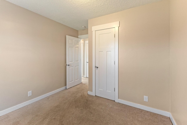 unfurnished bedroom with light carpet and a textured ceiling