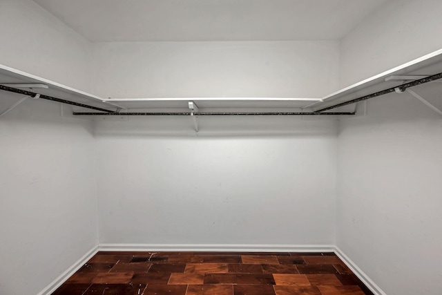 spacious closet with dark wood-type flooring