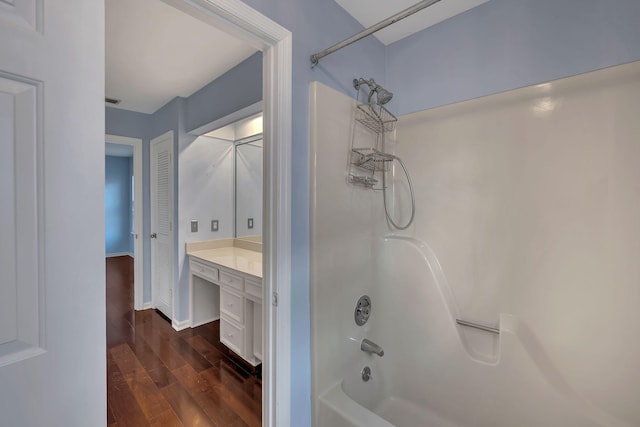 bathroom with hardwood / wood-style floors, vanity, and shower / bath combination