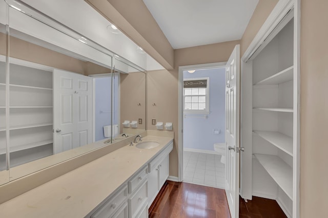 bathroom featuring toilet, vanity, and hardwood / wood-style flooring