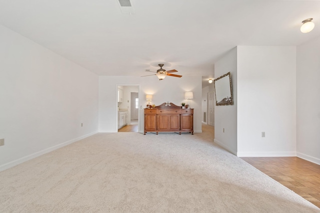 unfurnished living room featuring ceiling fan and light carpet