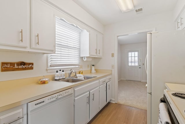 kitchen with white cabinetry, sink, light hardwood / wood-style floors, and white appliances