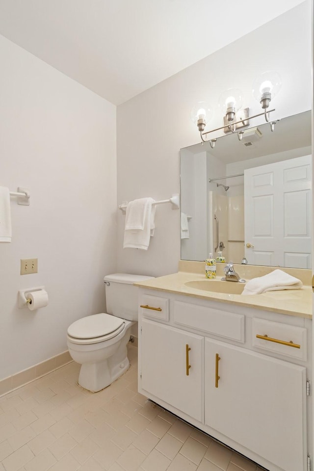 bathroom featuring tile patterned flooring, vanity, toilet, and walk in shower