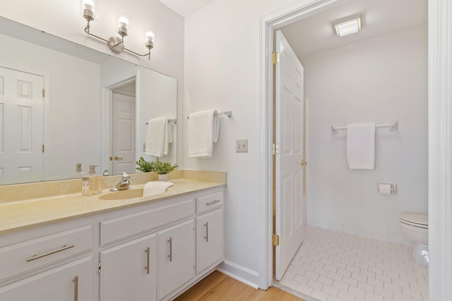 bathroom with hardwood / wood-style floors, vanity, and toilet