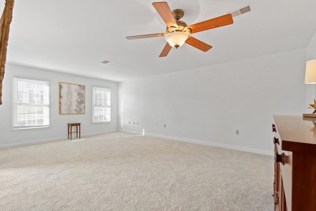 interior space with ceiling fan, plenty of natural light, and light colored carpet