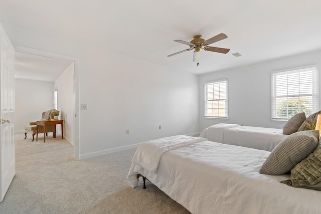 bedroom with light carpet, multiple windows, and ceiling fan