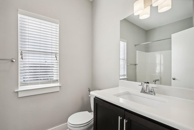 bathroom featuring a shower, vanity, and toilet