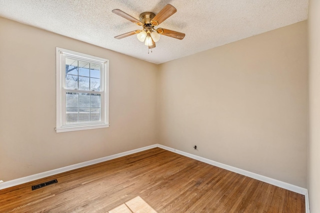 empty room featuring ceiling fan, a textured ceiling, and light hardwood / wood-style flooring