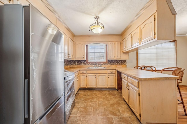 kitchen featuring light brown cabinets, sink, a textured ceiling, appliances with stainless steel finishes, and tasteful backsplash