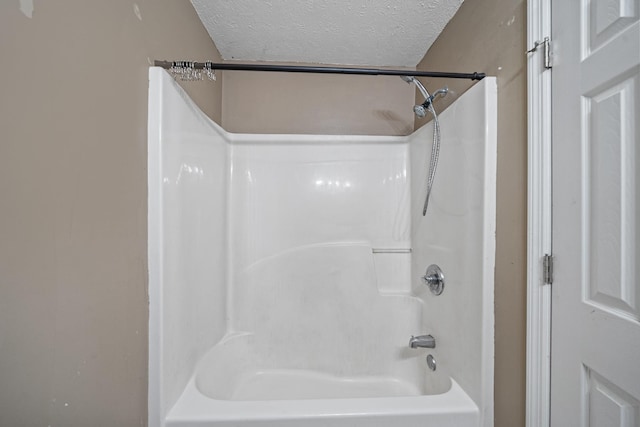 bathroom with  shower combination and a textured ceiling