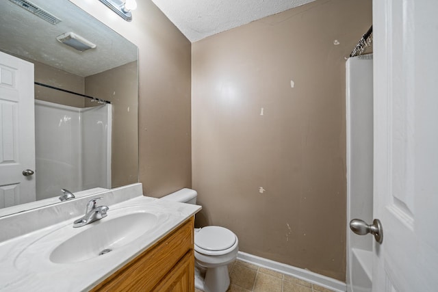 bathroom featuring tile patterned floors, vanity, a textured ceiling, and toilet