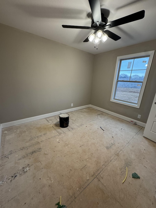 empty room with ceiling fan and baseboards