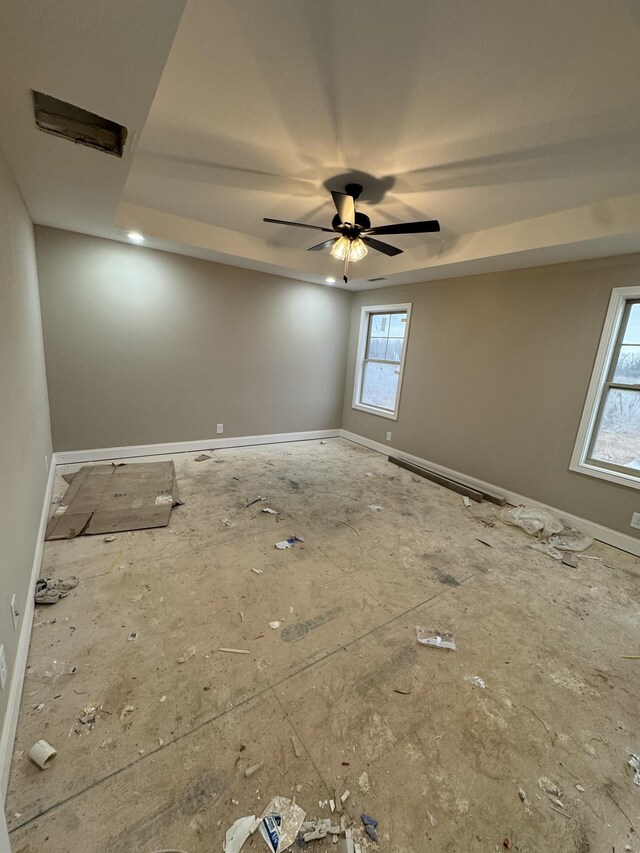 empty room with a ceiling fan and baseboards