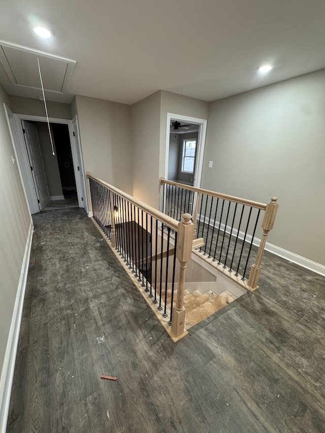 corridor with attic access, baseboards, wood finished floors, an upstairs landing, and recessed lighting