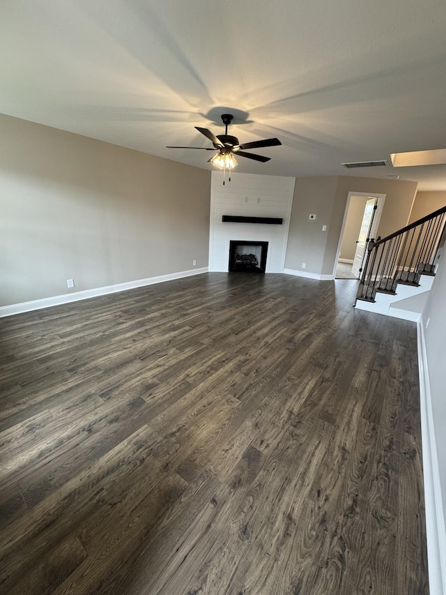 169 Anderson Pl, Clarksville, TN 37040 - unfurnished living room featuring dark wood-style floors, baseboards, a ceiling fan, stairs, and a fireplace