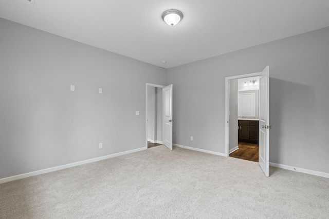 unfurnished bedroom featuring carpet floors and ensuite bath